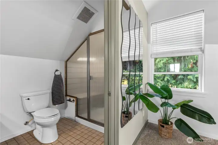 The adjoining bath features an updated vanity with generous storage and a spacious shower. The adjoining bath features an updated vanity with generous storage and a spacious shower.