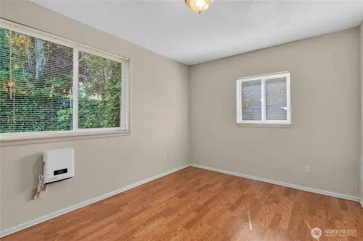 Main-level second bedroom features large windows, abundant natural light, and flexibility for guests, hobbies, or a home office. Main-level second bedroom features large windows, abundant natural light, and flexibility for guests, hobbies, or a home office.