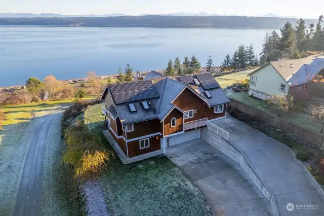 Lot runs down the slope on a community maintained road to this home's private beach and large natural estuary.