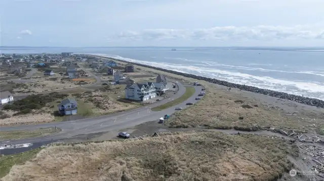 AERIAL VIEW OF THE CONDO (MIDDLE BUILDING) SHOWING THE PARKING LOT ACROSS THE STREET AS WELL AS THE TRAIL TO THE BEACHES!