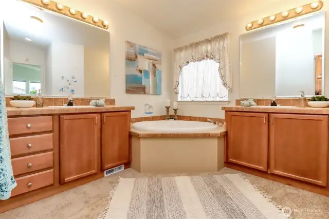 Soaking tub and separate vanities off primary bedroom.