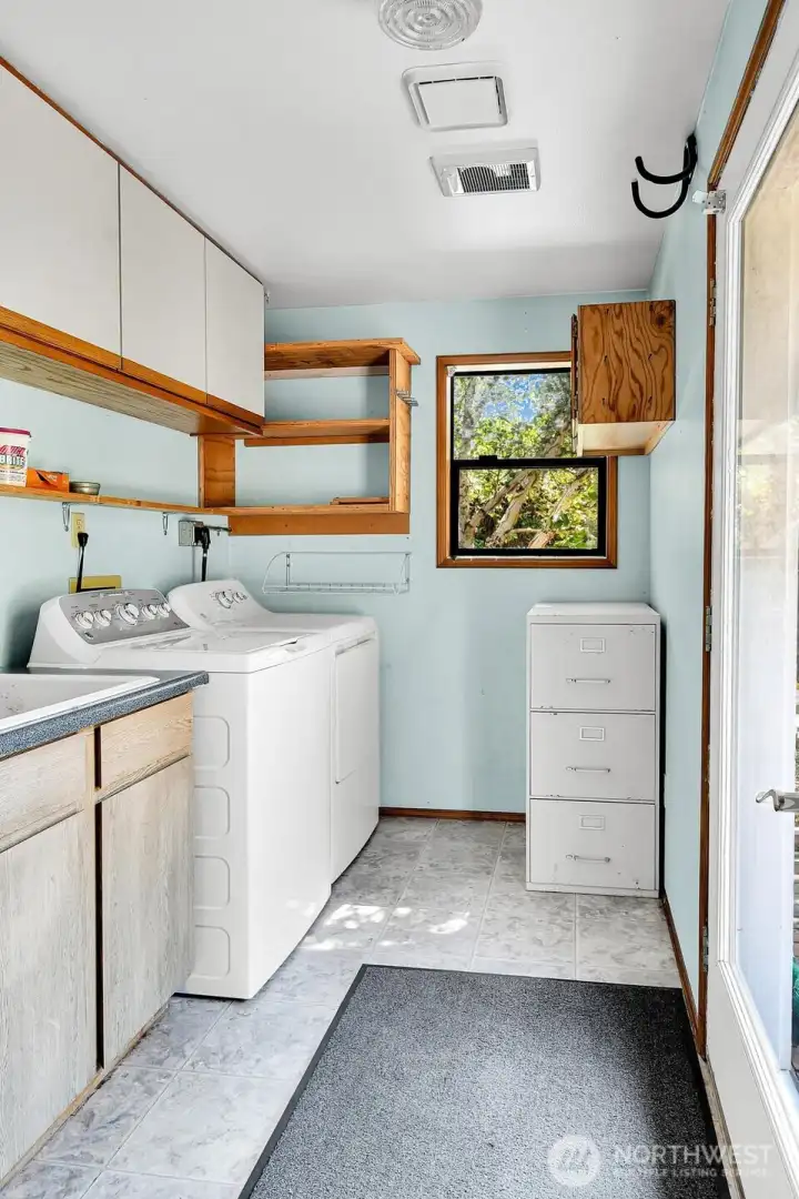 Laundry room with utility sink and ample storage.