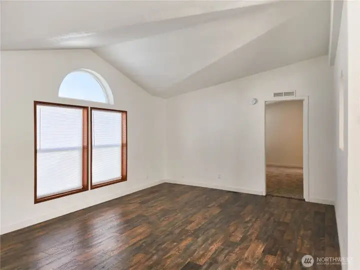 Elegant custom arch window, vaulted ceiling detail create a beautiful focal point, flooding the room with soft natural light and timeless style.