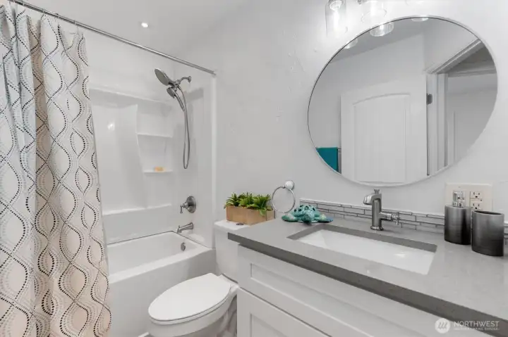 Bathroom with new tub/shower surround. Quartz counter. All fixtures are new.