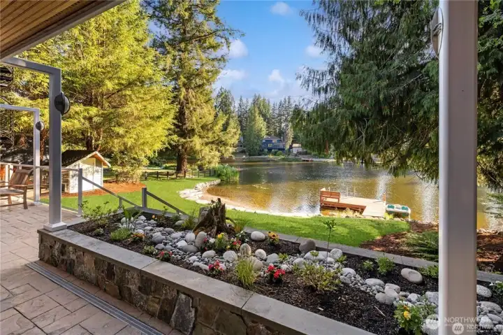 Entertaining main level patio with natural gas hookup for bbq, looks out to groomed lawn and your own private rare sand beach.