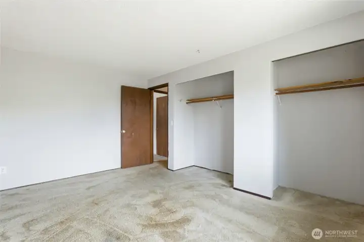 Main level guest bedroom with dual closets for ample storage.