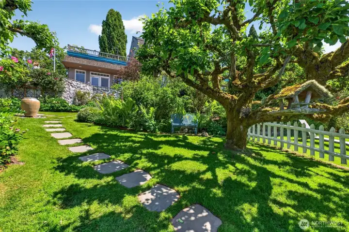 Path winding through the lush gardens, leading to the Guest Cottage and places to relax, like under the trees.