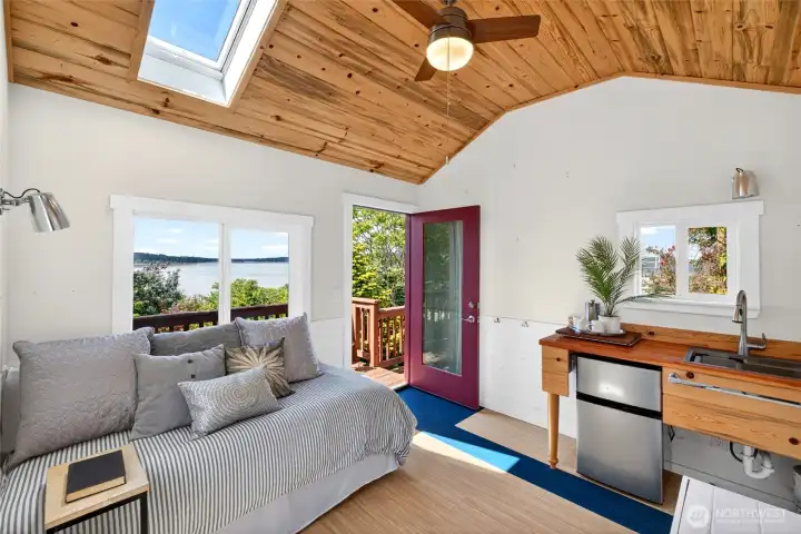 Interior of Guest Cottage with sink, small frig and a self-contained portable toilet. Also a sky light in ceiling. Magnificent views from window and outside on porch.