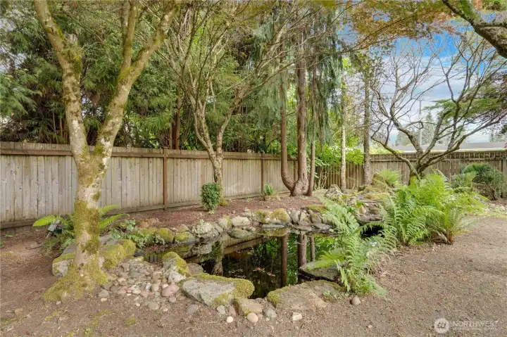 A backyard pond enhances the peaceful Pacific Northwest atmosphere, while full fencing adds privacy and enclosure. A backyard pond enhances the peaceful Pacific Northwest atmosphere, while full fencing adds privacy and enclosure.