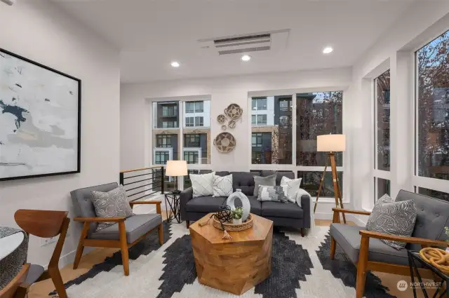 The spacious and inviting living room is perfect for cozy evenings or lively gatherings. Oversized windows frame Capitol Hill’s vibrant energy.