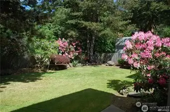 The landscaped back yard has flowering brush and is very private.