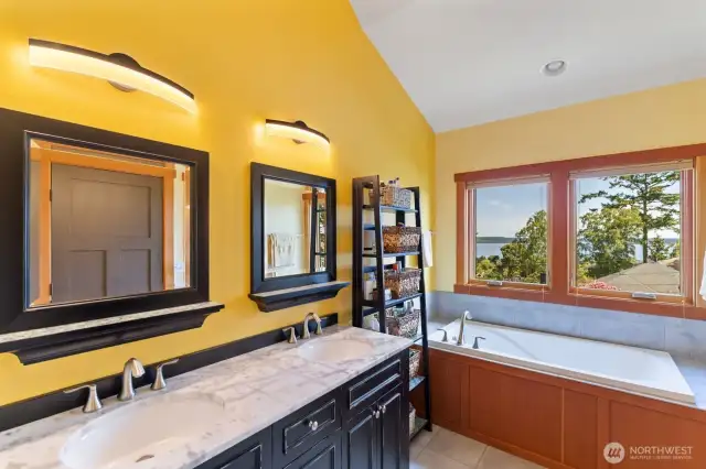 Double sink, designer cabinet, and large tub for relaxing.