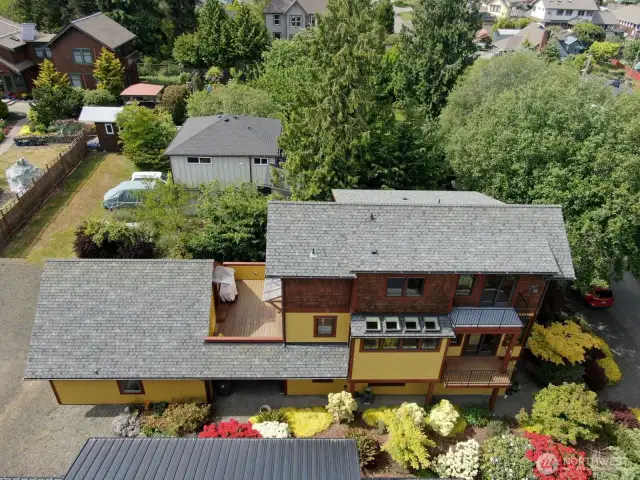 Aerial of the home, sunny deck, and 2 balconies.