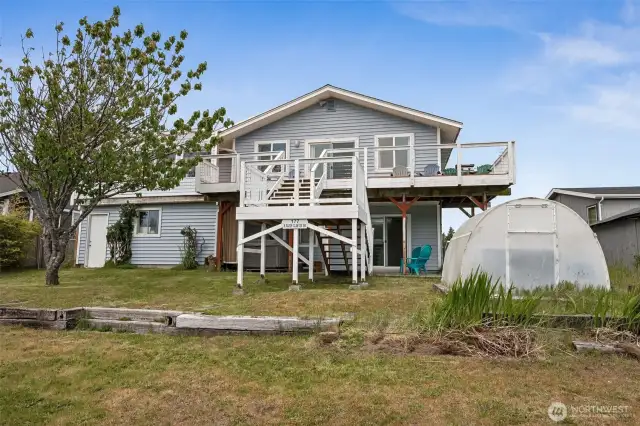 Large back yard with greenhouse and access to the upper deck.