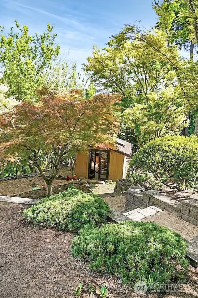 The custom outbuilding with skylight offers extra storage and/or a yoga room or other uses.