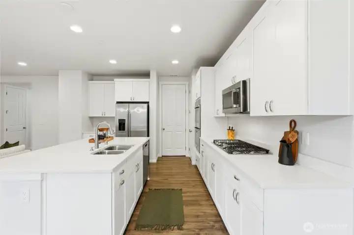 Kitchen features quartz countertops, stainless steel appliances and lots of cabinets