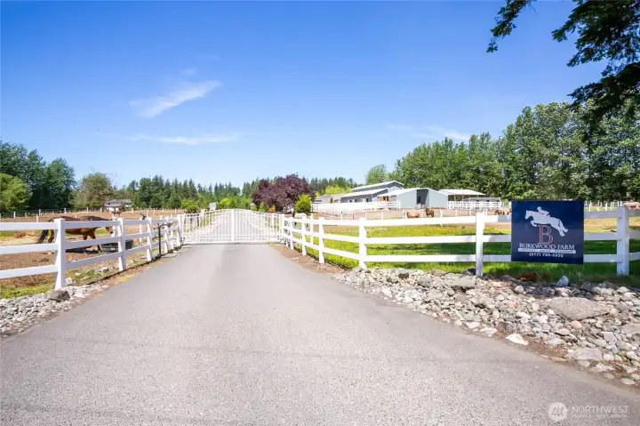 Gated entrance and paved driveway with ample parking for cars, trucks and trailers.