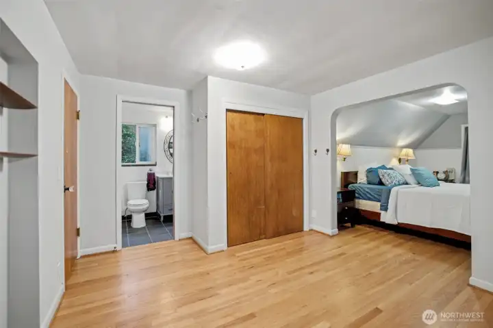 A wonderful primary suite located on the upper level is filled with classic charm and a framed archway into the bedroom area.