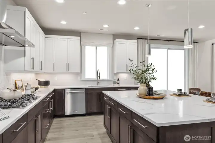 Well-appointed kitchen with large center island with quartz counters. Photo is representational. Actual home is under construction and materials, colors, and finishes will vary. See site agent for details.