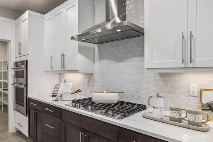 Home is still equipped with GAS cooktop and separate wall mounted range hood. Photo is representational. Actual home is under construction and materials, colors, and finishes will vary. See site agent for details.
