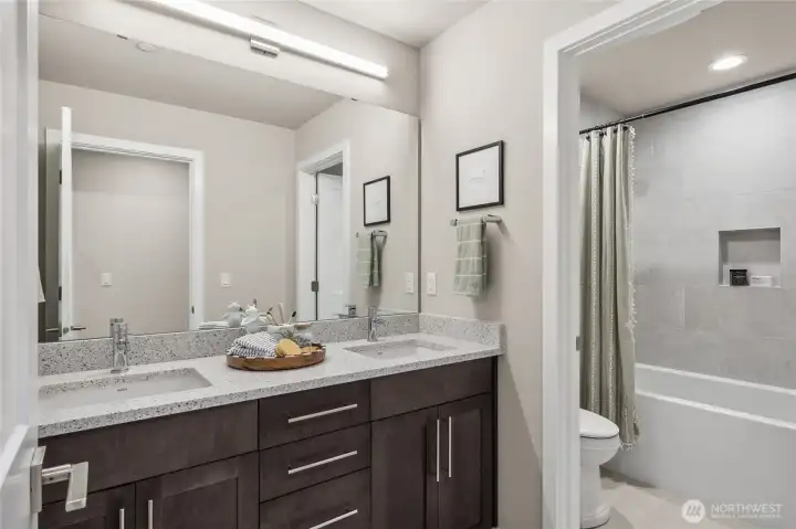 2nd full bathroom with double vanity, notice the door separating shower for multiple people to get ready for the morning. Photo is representational. Actual home is under construction and materials, colors, and finishes will vary. See site agent for details.