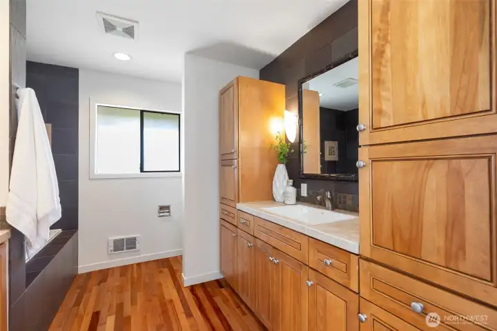 Hallway bath with soaking tub, divided toilet area, and plenty of storage