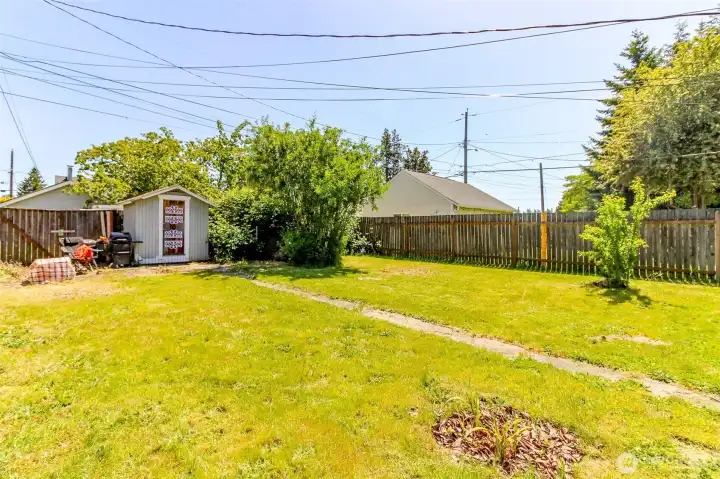 The backyard has a shed and a cement patio which used to be where the garage was.