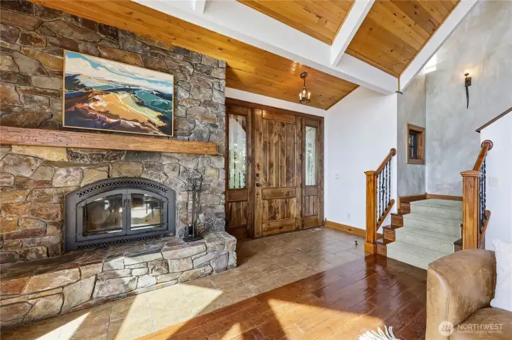 Stone fireplace, vaulted tongue-and-groove ceiling, staircase to the primary suite.