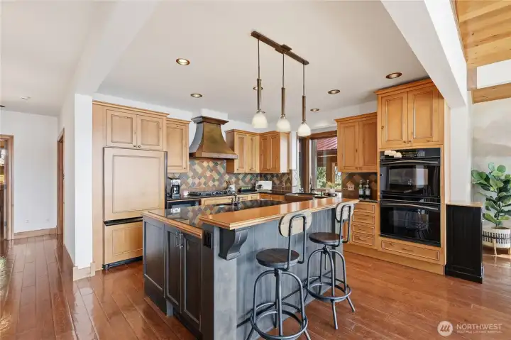 The island anchors a kitchen built for real cooking...double ovens, gas cooktop, & generous prep space.