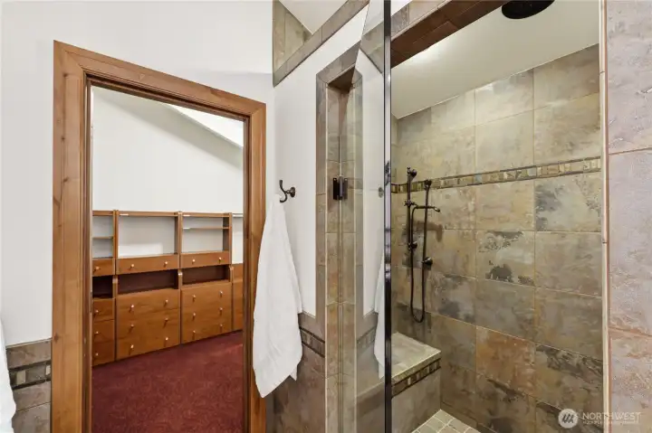 Tiled walk-in shower with dual fixtures.