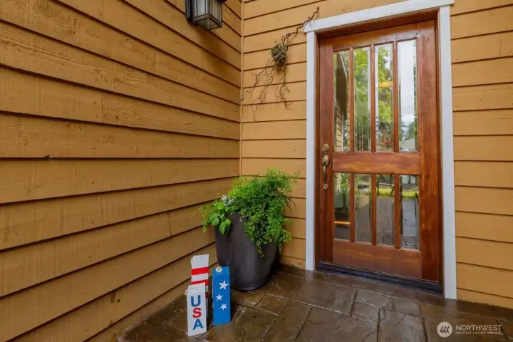 Beautiful cedar siding and wood door leads into the home.