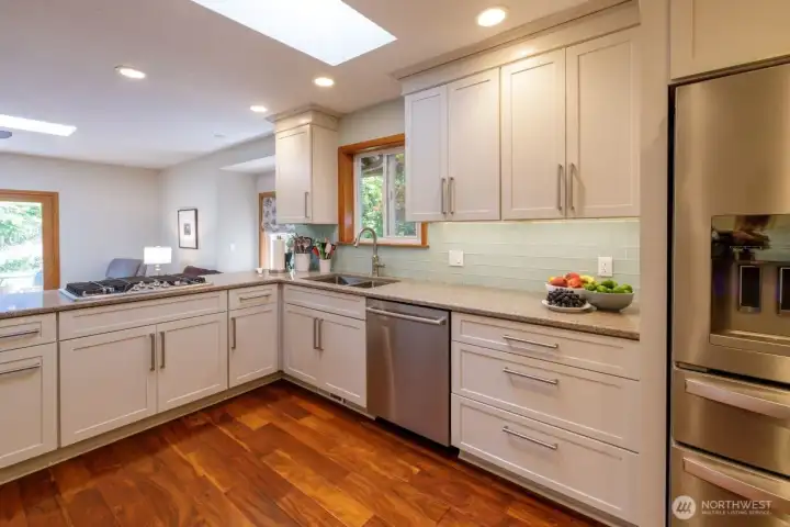 Updated kitchen with quartz countertops. stainless appliances, wood-wrapped window over sink, and updated cabinetry.
