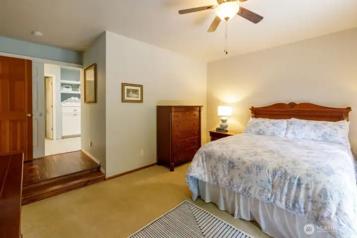 On the back of the home, on one wing is the true primary ensuite with a spa feel.  From the step-down bedroom, beautiful French doors access the Trex deck and the incredibly landscaped yard.