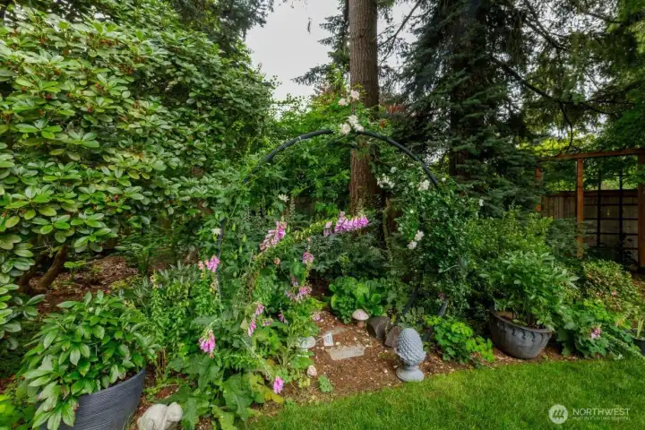 Lush garden surrounds the home.  Carefully chosen and maintained plantings surrond the home. Fully fenced with gate access to the community greenspace behind.