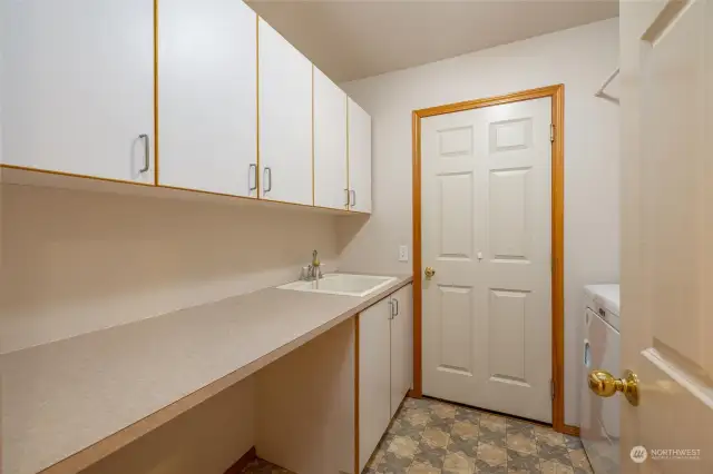 Laundry room with door to garage. Utility sink, and lots of counter and storage space.