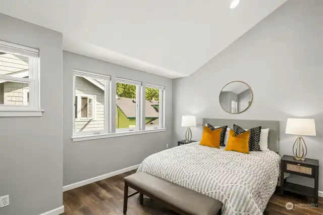 Primary bedroom with vaulted ceilings and new LVP flooring.