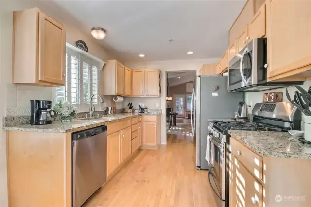 Terrific kitchen with slab granite counters, stainless steel appliances, gas cooktop, hardwood floors & great eating nook