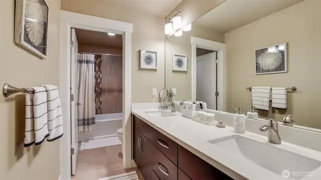 Full upstairs bathroom with tile flooring & tile tub surrounds. Double sinks with lots of storage.