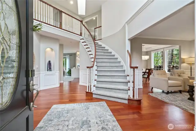 The Grand entry with dramatic staircase and high ceilings invites you in. Rich hardwood floors and traditional wainscoting blended together.