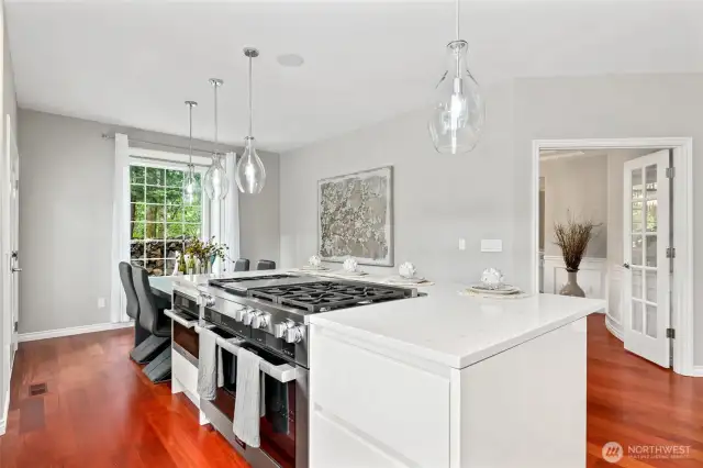 Commercial Miele Range with double ovens next to built in Microwave