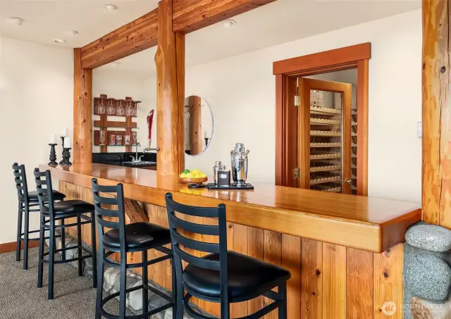 Wet bar has gorgeous wood bar with log supports masterfully incorporated. Fine craftsmanship defines all the woodwork in the home. Wine cellar is convenient to the bar.