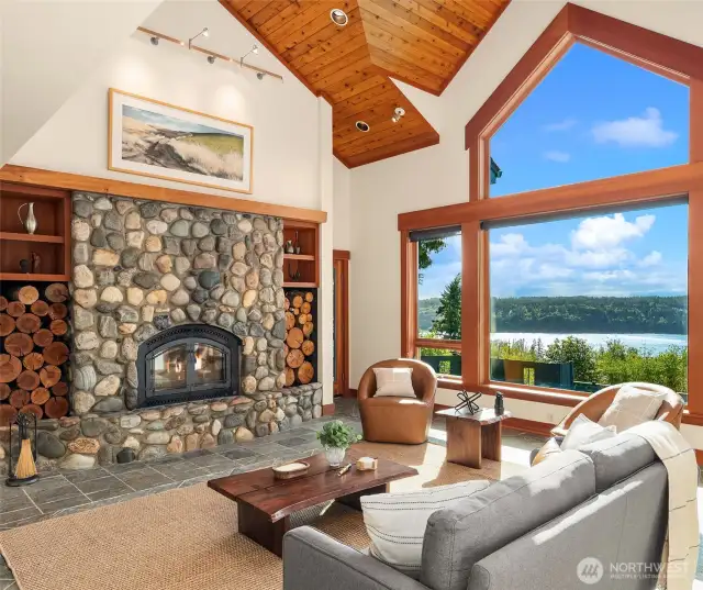 Soaring wood-clad ceilings, slate floors and stone fireplace with wood insert grace the living room.