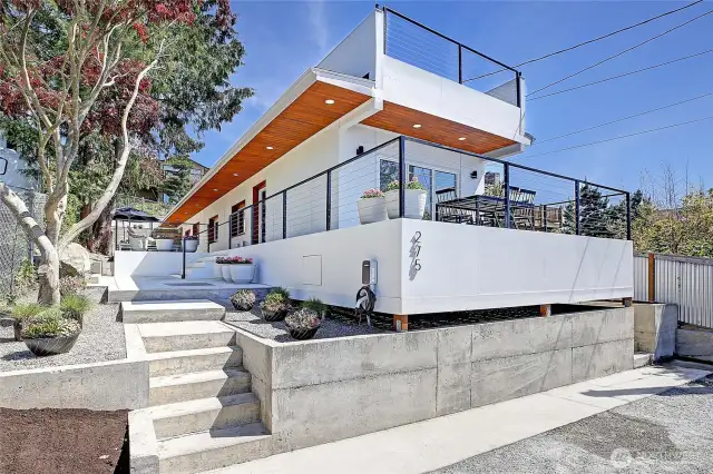 Front of home. Modern exterior cement plank siding. hardscaped entry and 4 parking spots out front.