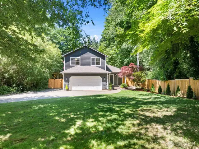 Front yard surrounded by established trees.