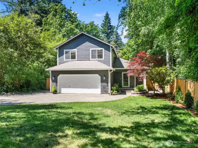 Front yard surrounded by established trees.