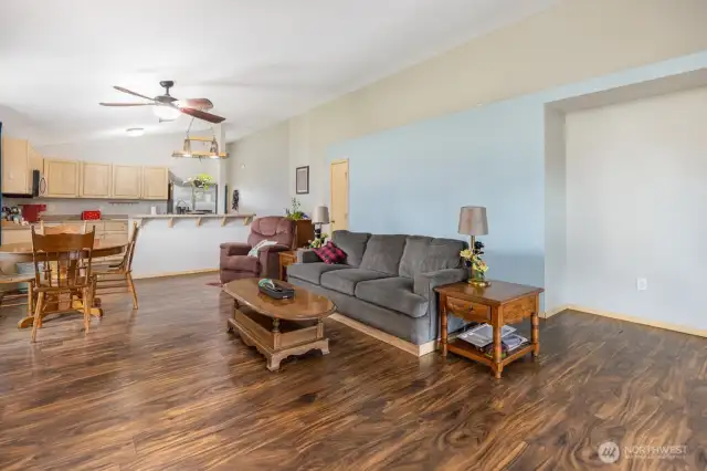 Living room opens to dining and kitchen and has a sliding door to the covered patio