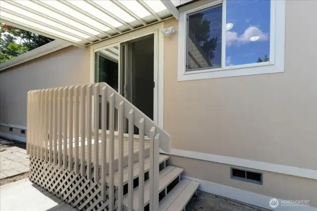 Back porch is covered and opens onto the driveway and small patio area.