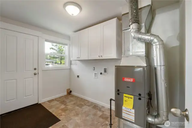 Spacious utility/mudroom with plenty of room to double as a pantry