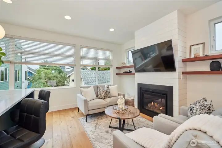 The modern farmhouse aesthetic carries into the living room with ship lap fireplace surround and custom built reclaimed wood shelves.