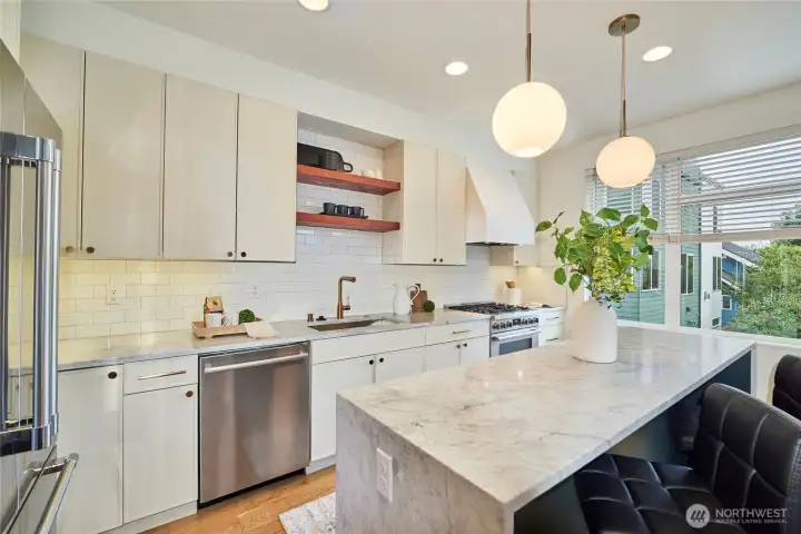 The Chef's kitchen is a "dream come true" with quartz countertops including a double waterfall edge island, Bertazzoni gas range with custom built range hood, Wi-Fi enabled Bosch fridge, undercabinet lighting and reclaimed wood shelves. Wow!
